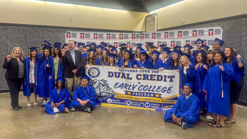 A group of student smiling and holding a banner