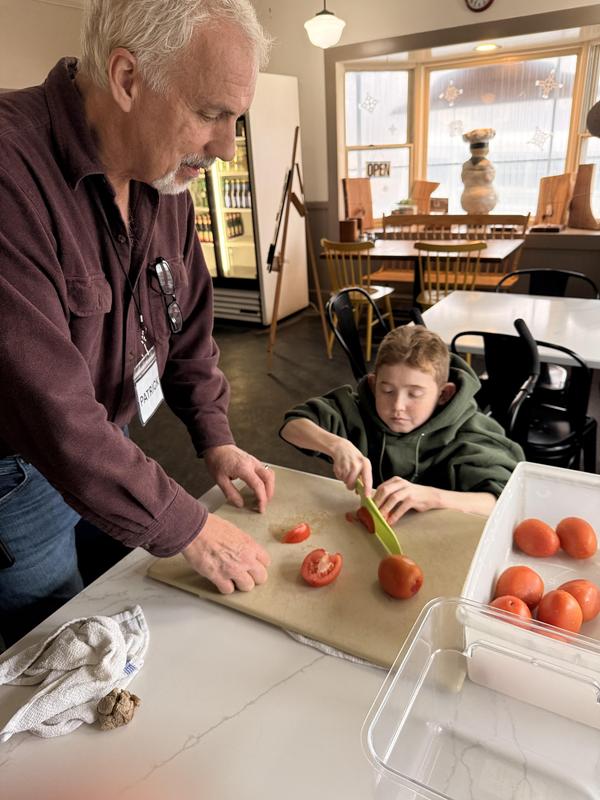 Patrick O'Hearn teaches a PEP student how to make a pizza