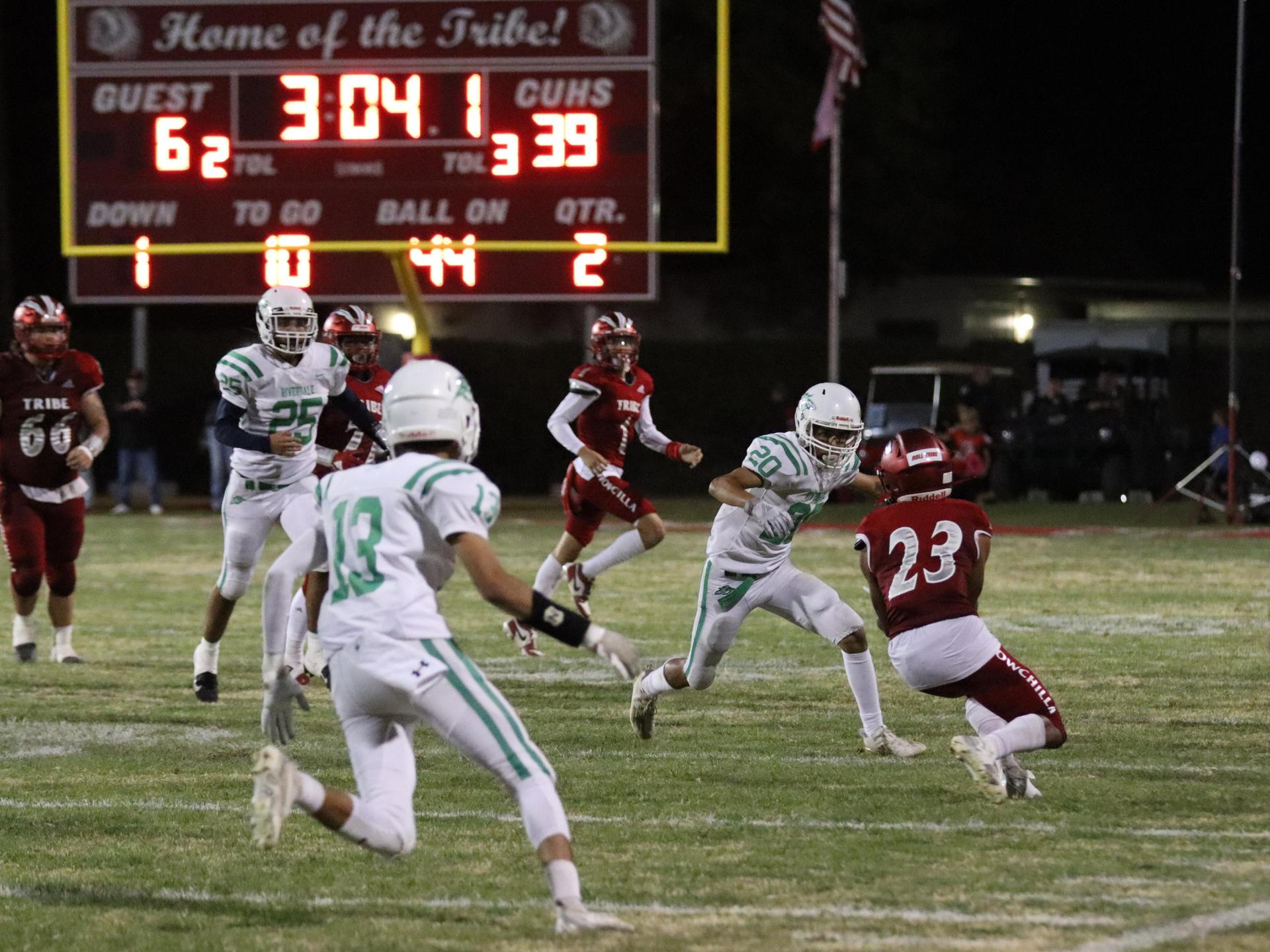 varsity football players in action against Riverdale