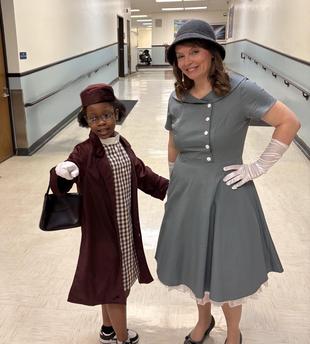 Girl and woman in vintage outfits posing together in a corridor.