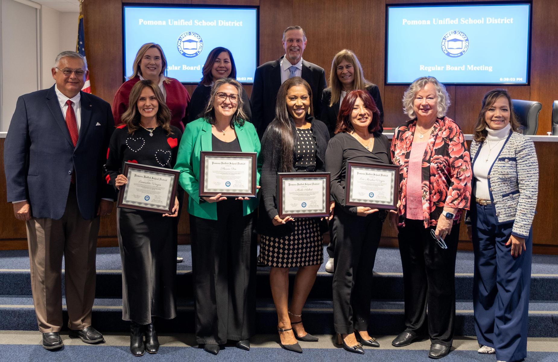 11 persons in school board room pose for photo with admins