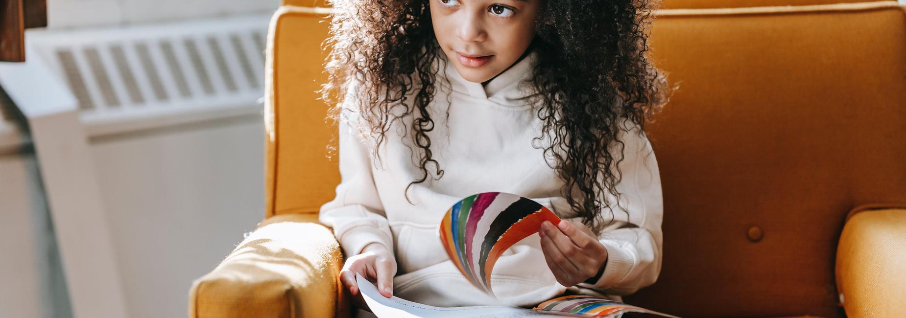 student with curly hair reading a book