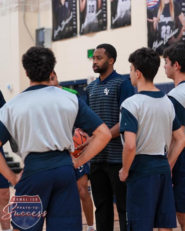 - Smithson Valley High School Basketball Team in a huddle with Assistant Coach Isaac Thornton