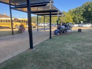 students writing under the awing in the senior lot