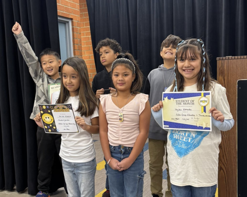 Students celebrating their achievements posing for photo on stage