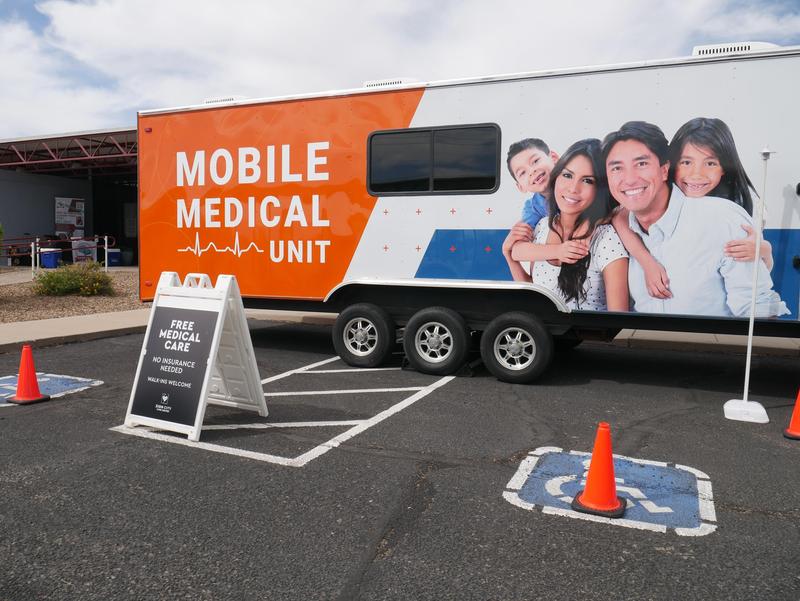 Mobile health clinic parked in front of a school