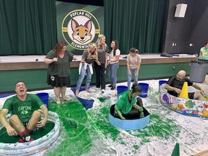 Adults getting covered in lime green slime.