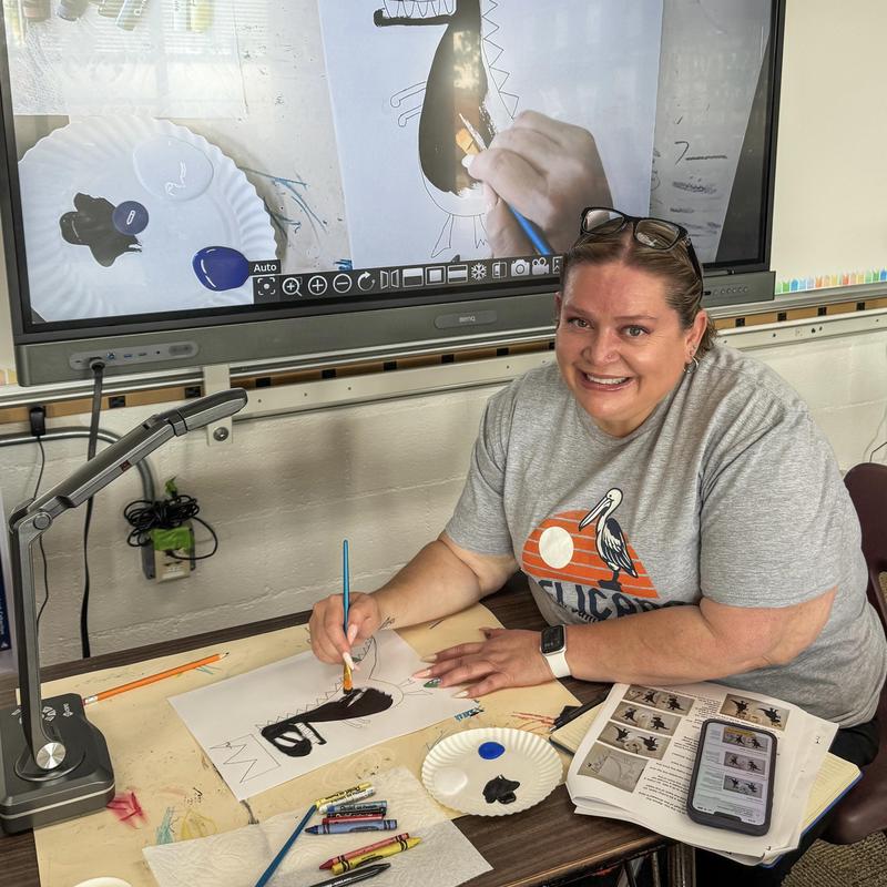 Volunteer Smiling and Painting a Bird