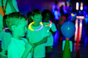 Students at a glow in the dark fun run wearing glow bracelets and necklaces.