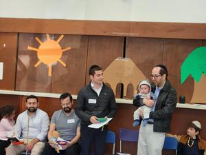 The parents performing the parsha for the students.