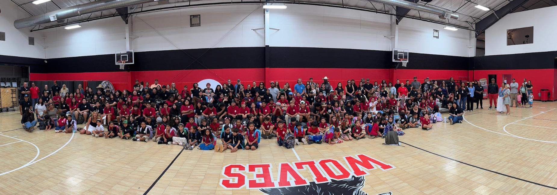 A large group of people gathered in a gymnasium, posing for a group photo.