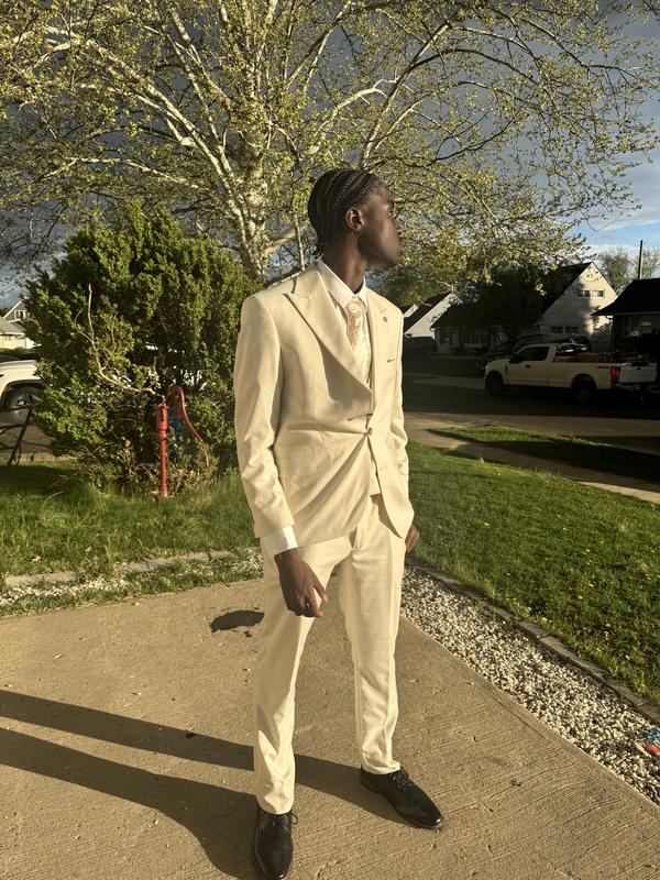 Full-length photo of Samuel in a cream suit.
