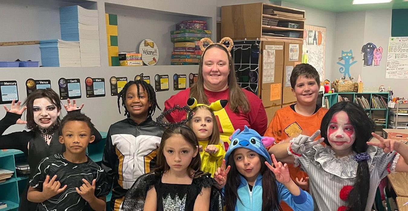 Group of children in Halloween costumes posing for a photo.