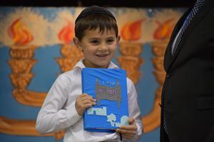 A first grader recieives his siddur
