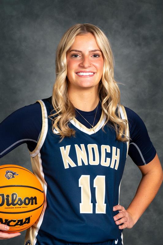 blonde hair girl basketball player in uniform holding basketball