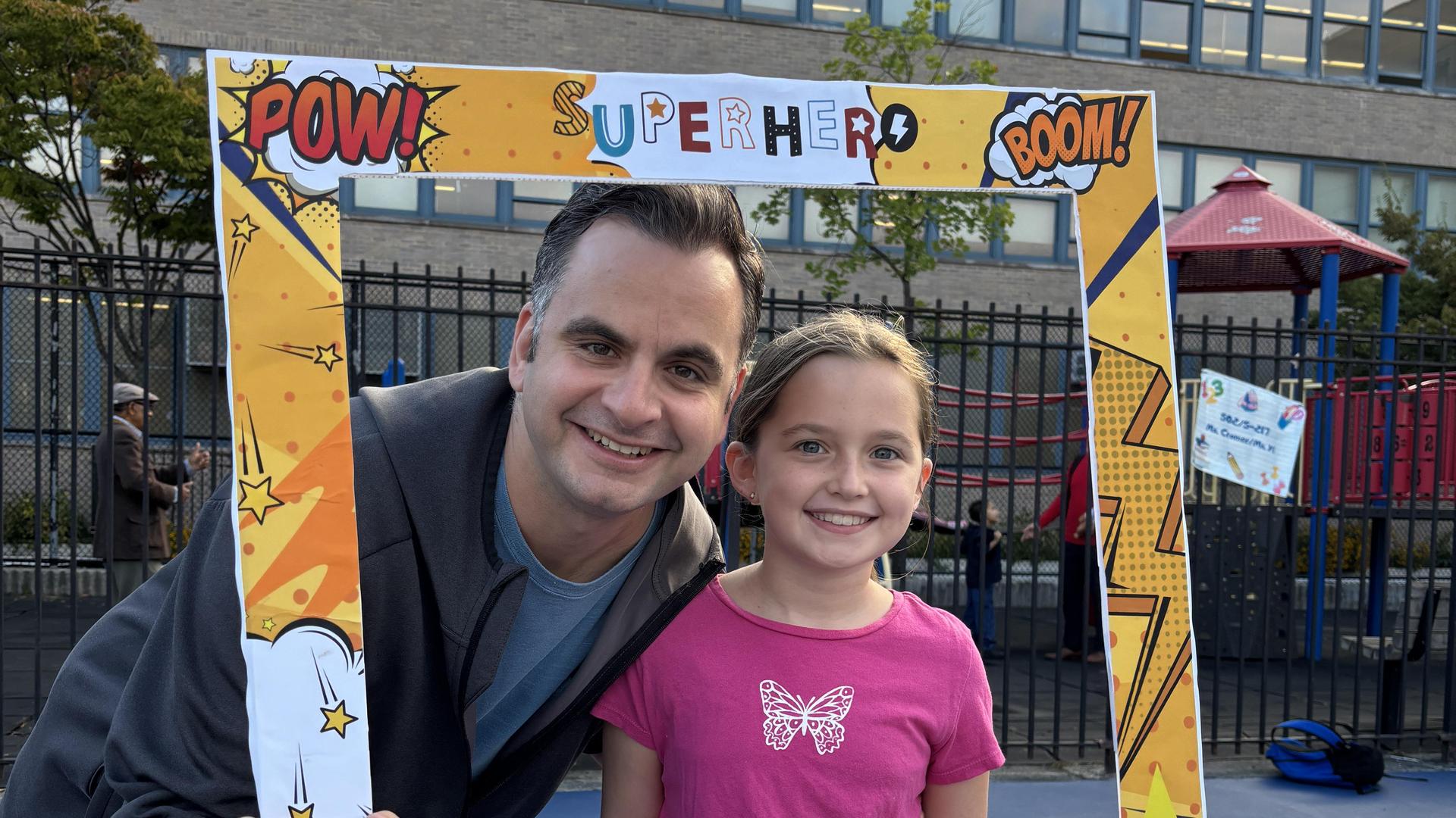 Adult and child posing together in a colorful frame.
