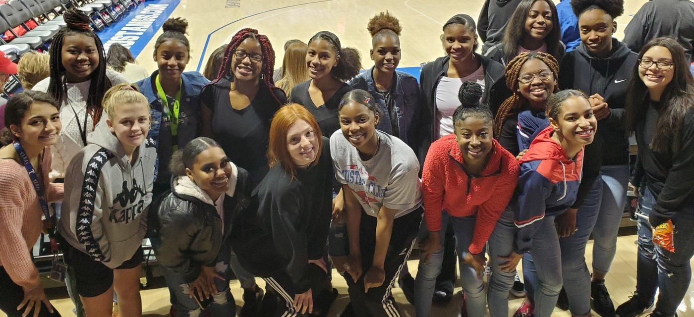 Lady Indian Basketball players courtside at a college game