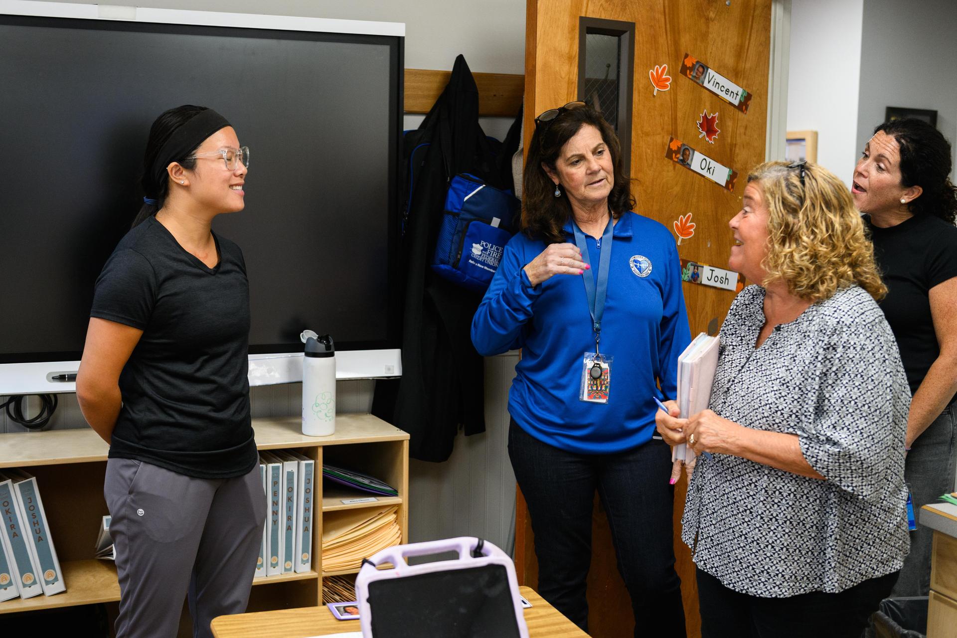 3 teachers standing and talking