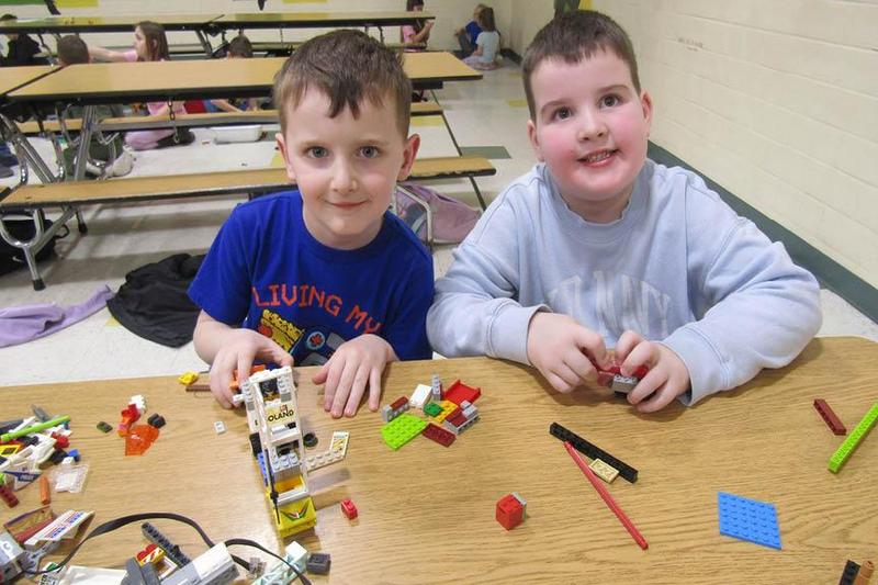 Kindergarteners Wesley Pahel and Henry Wagner build their Lego structures while sitting side by side at a table