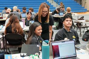 counselor helping students with laptops