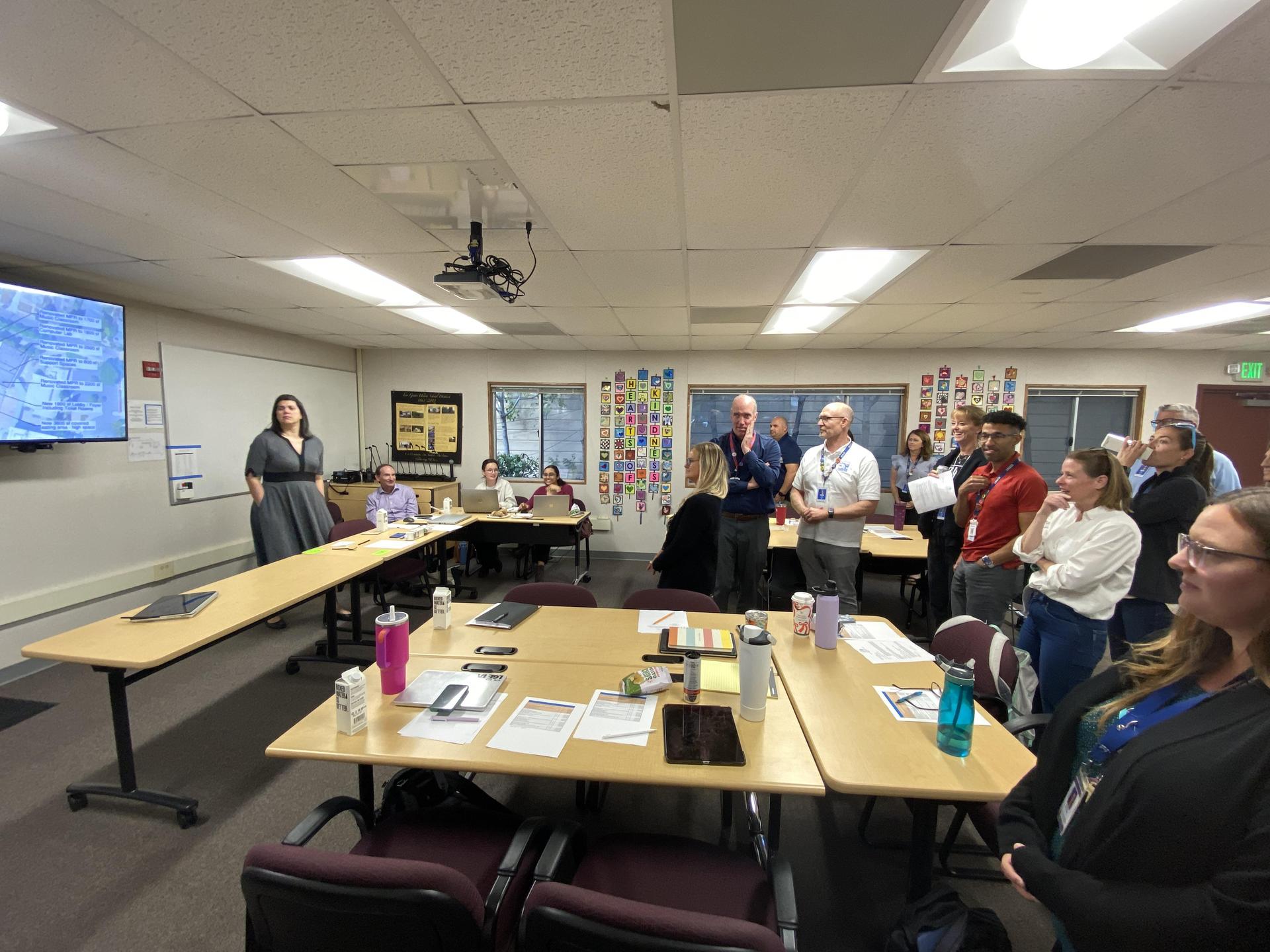 People standing and looking at construction designs.
