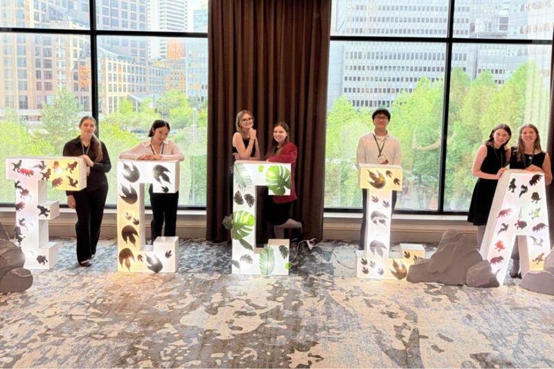 Students competiting in the FCCL state contest standing behing FCCLA letters in front of a window