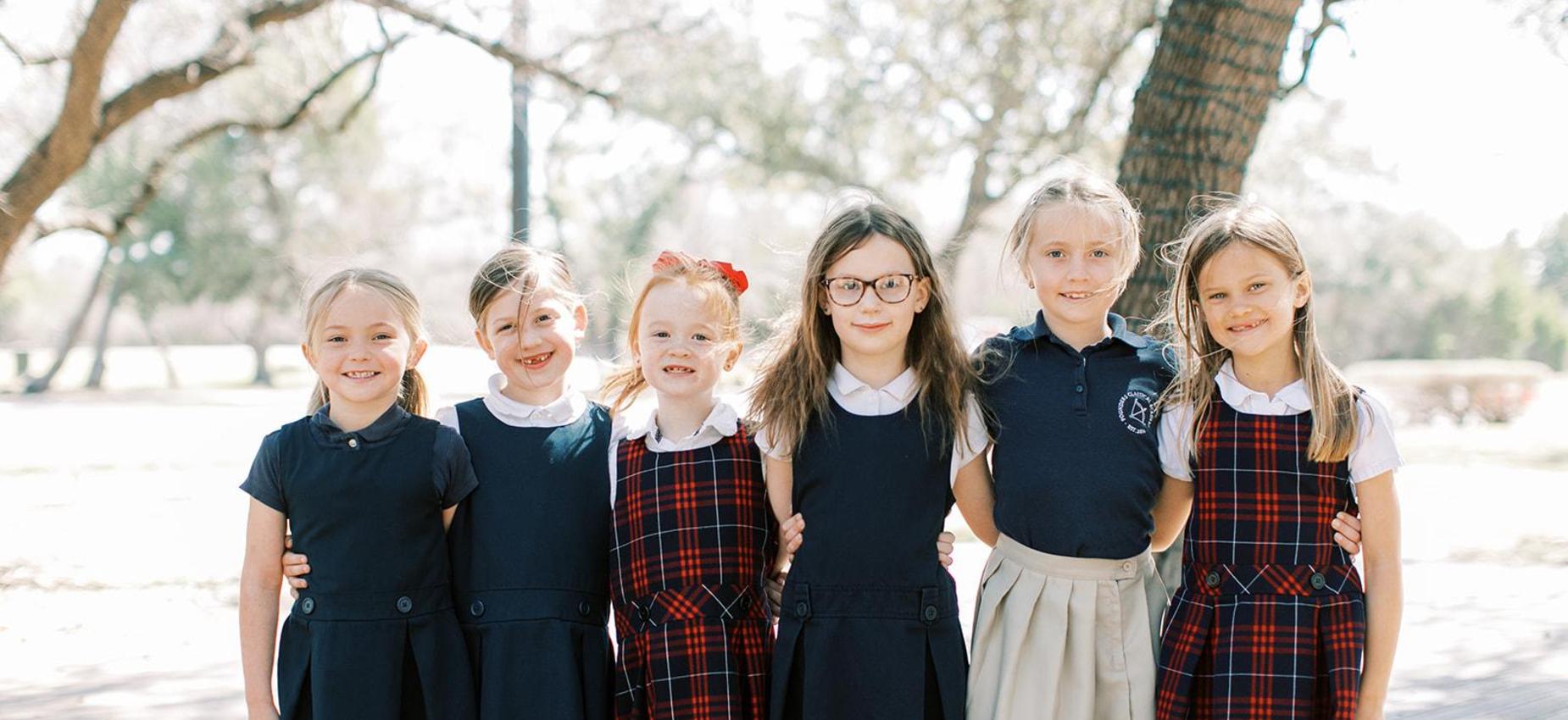 Six elementary girls in Founders uniforms stand together outside