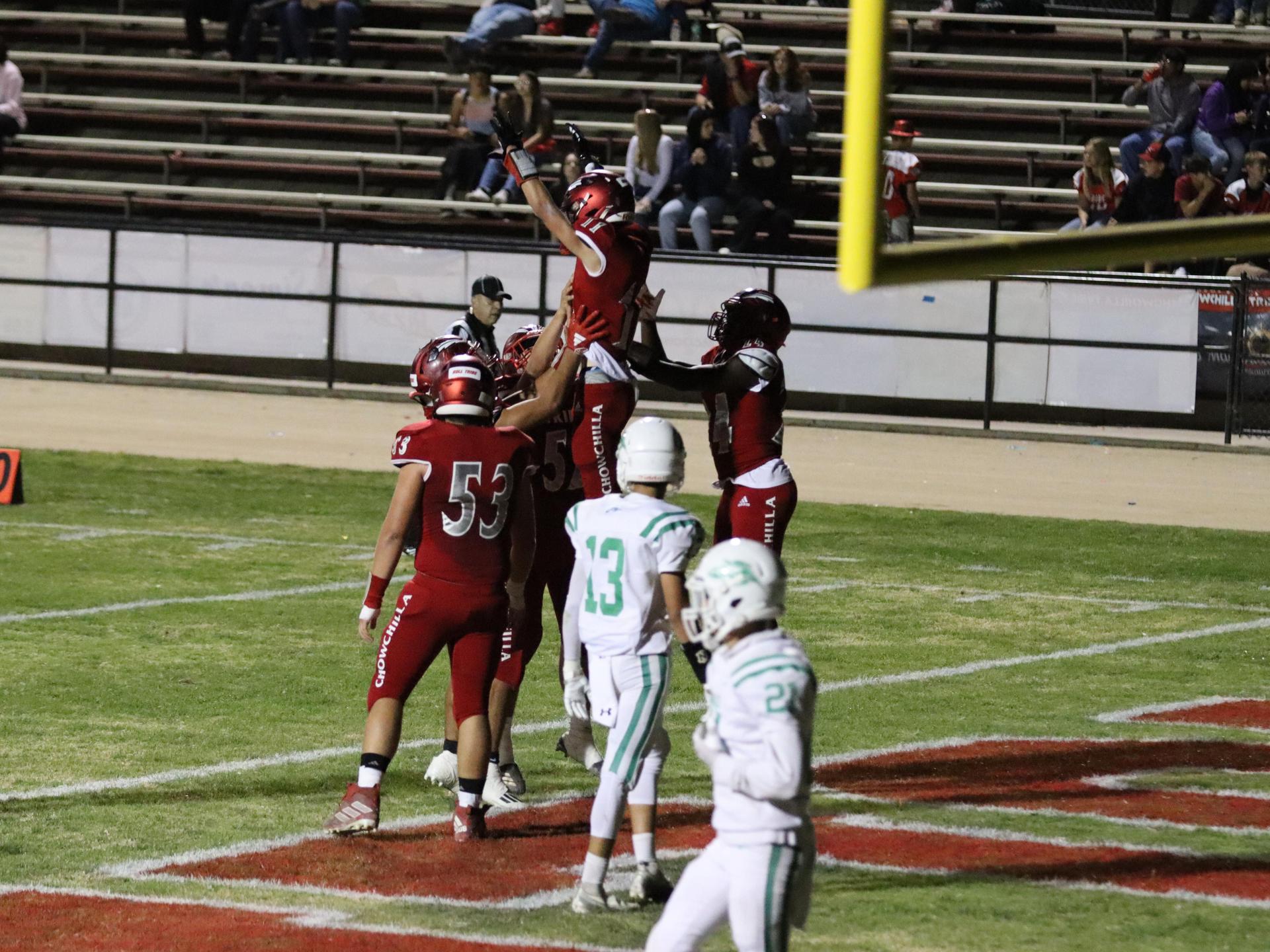 varsity football players in action against Riverdale