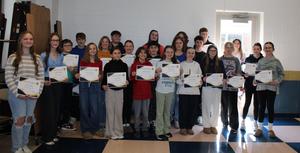 group of middle school students in cafeteria holding certificates