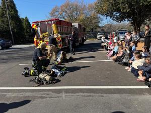 Two firefighters racing to see who can gear-up faster
