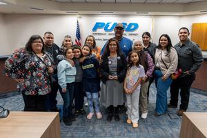 Felipa Ruiz holds her recognition award and poses with family and supporters at the PUSD Board meeting.