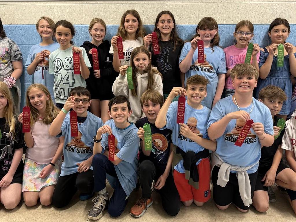 Reading Olympics students holding up their ribbons.
