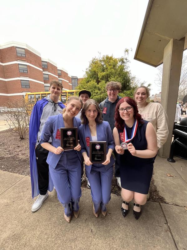 group of OLSH students, two hold plaques, one has a medal
