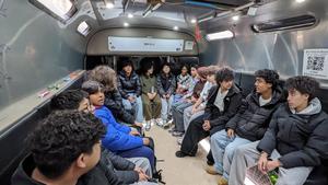 Group of teenagers seated inside the BIOBUS, participating in a science session.