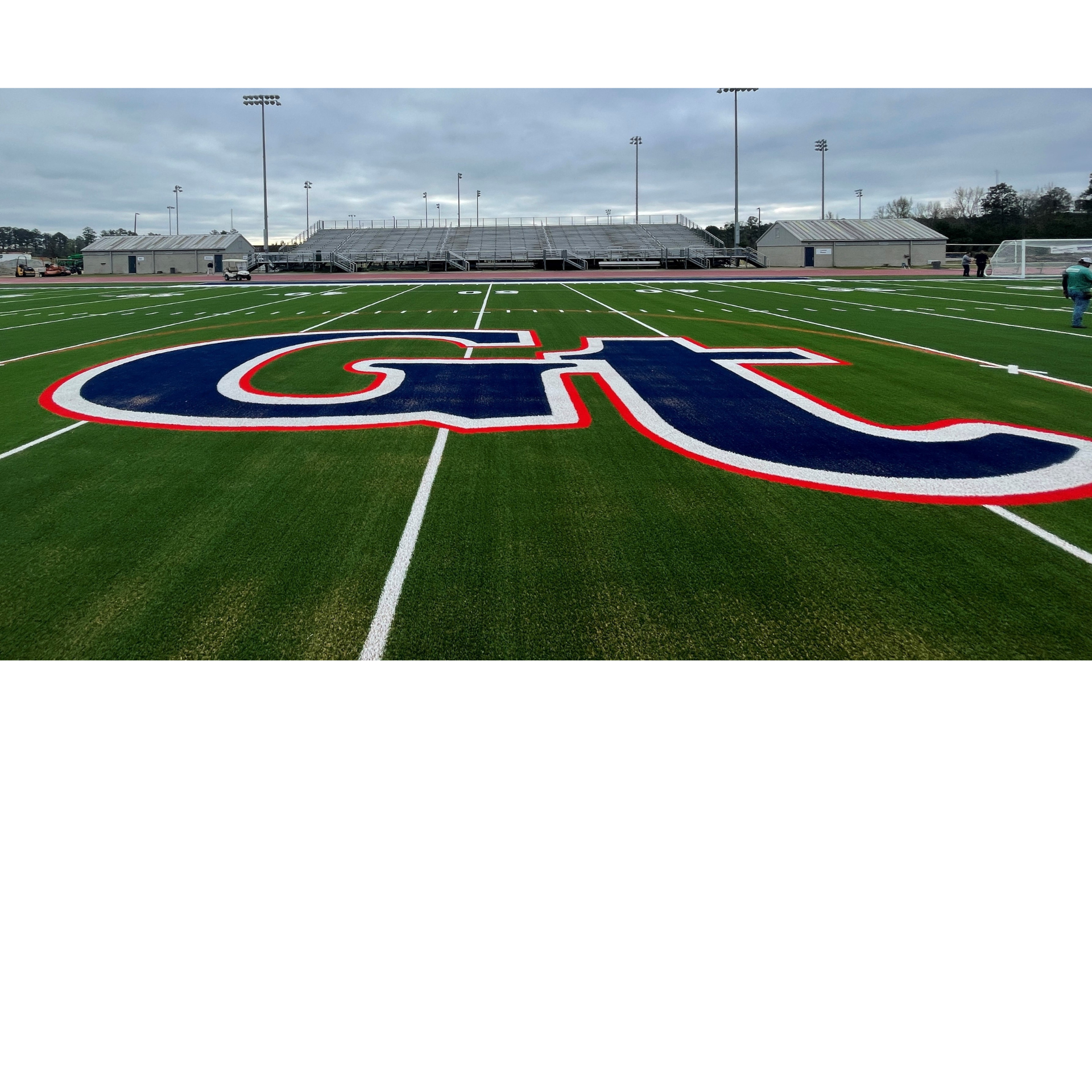 A football field featuring a large red, white, and blue 'GT' logo at the center.