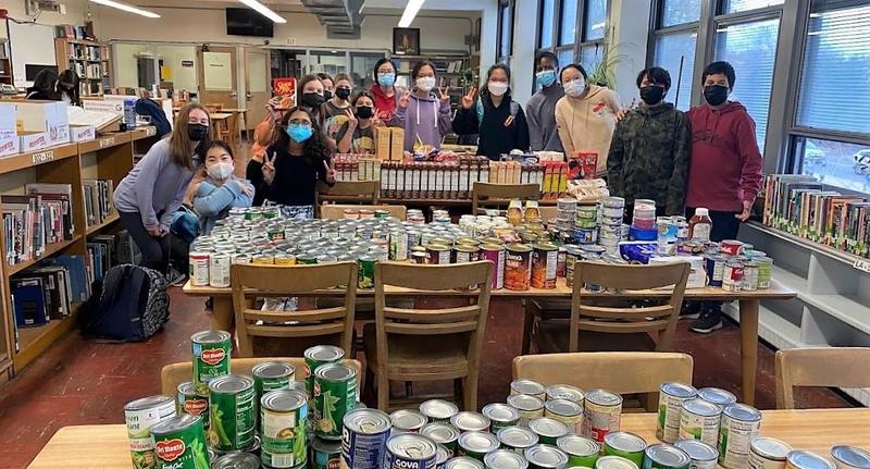 Photo of members of the Edison Student Government Association posing with nearly 1300 pounds of food to be donated for Thanksgiving.