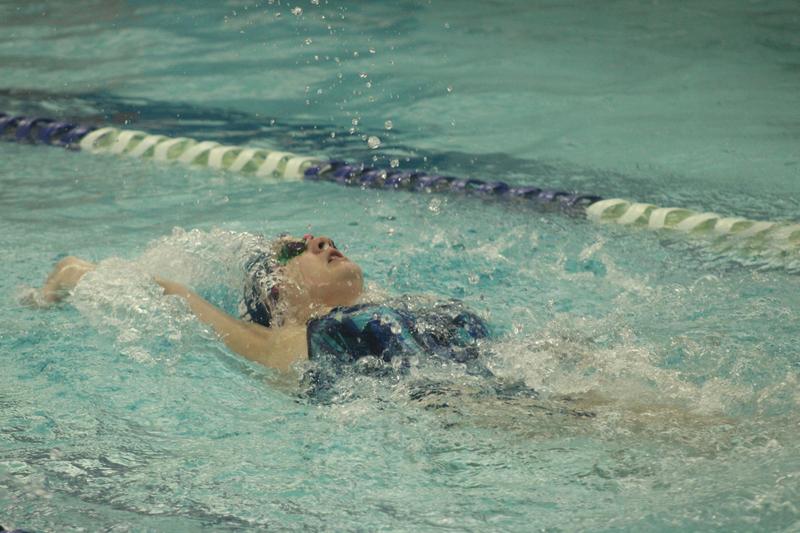 Girls swimmer does the backstroke