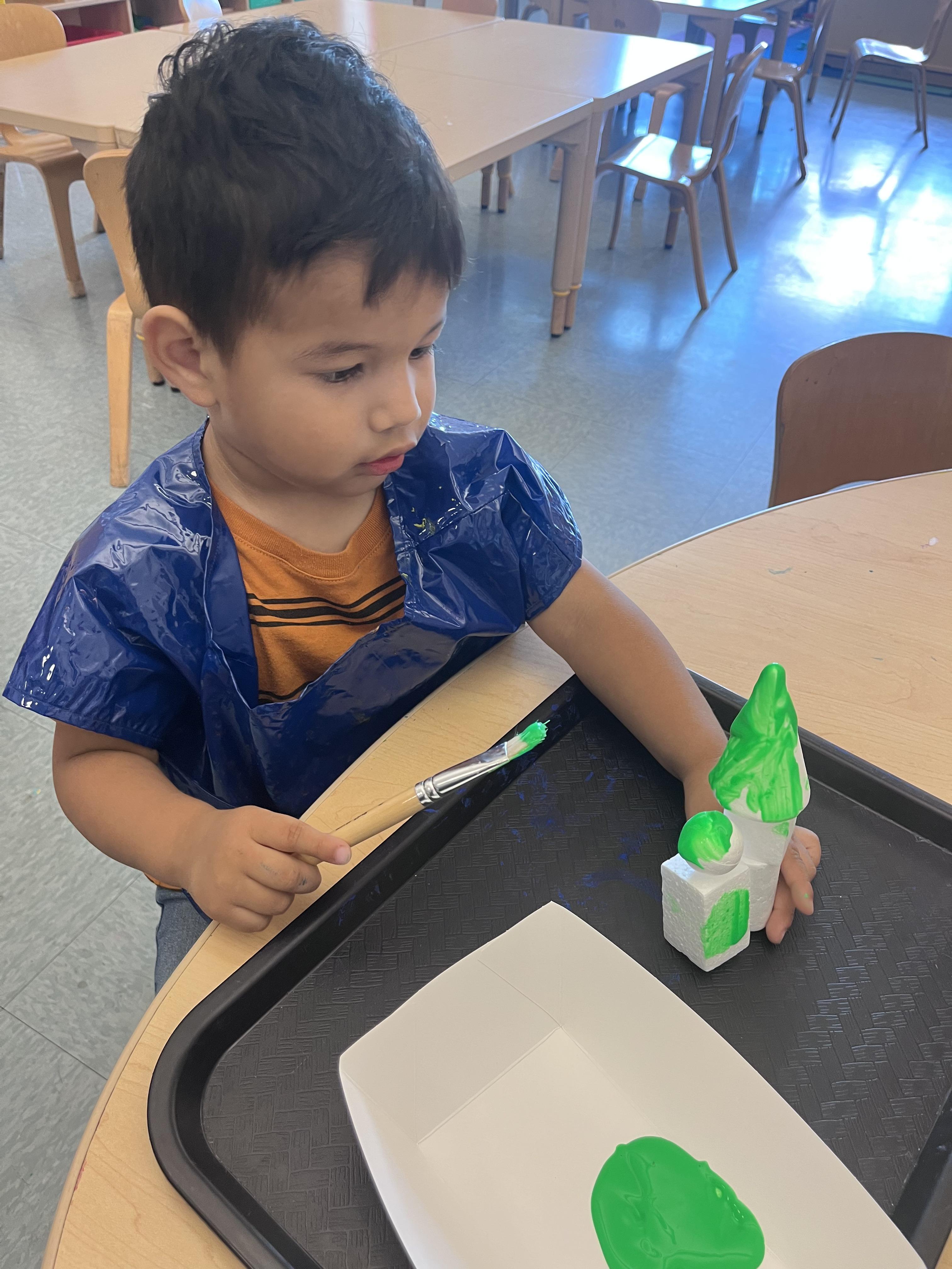 Emmanuel painting his building