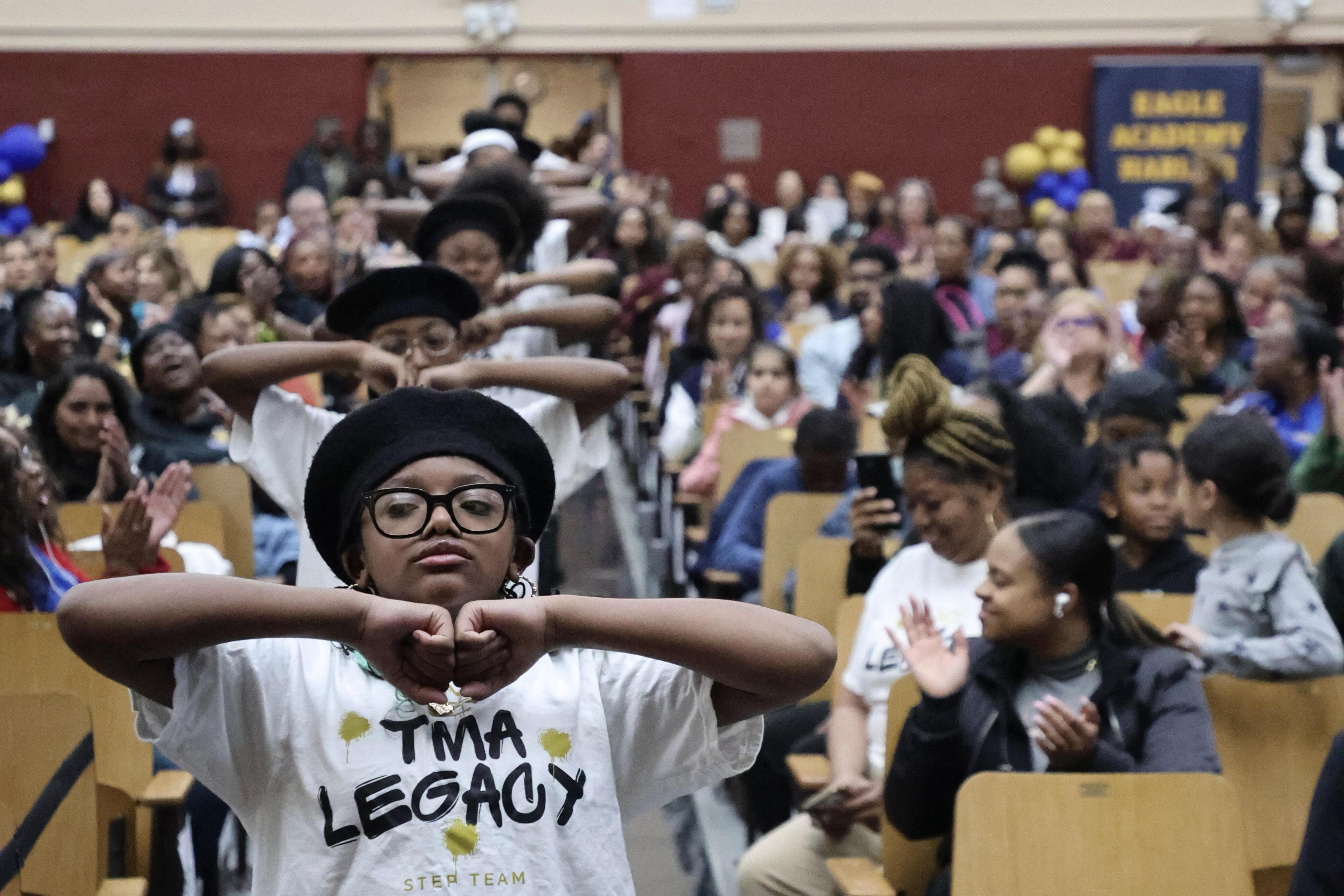 A lively audience watching performers at the Eagle Academy for Young Men of Harlem.