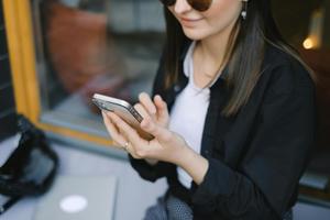 An adult in business attire checks a smartphone screen