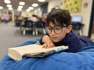 boy elementary student reading book
