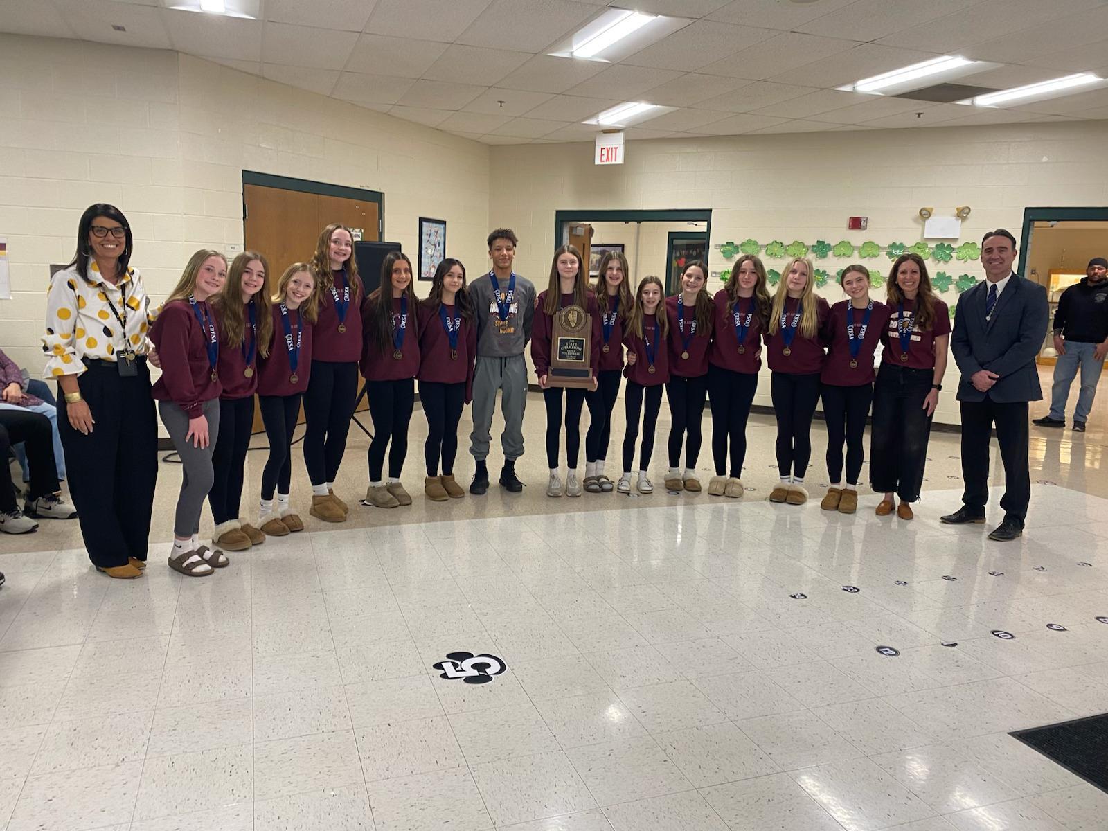 State Championship Volleyball Team and Wrestler smile with administrators.