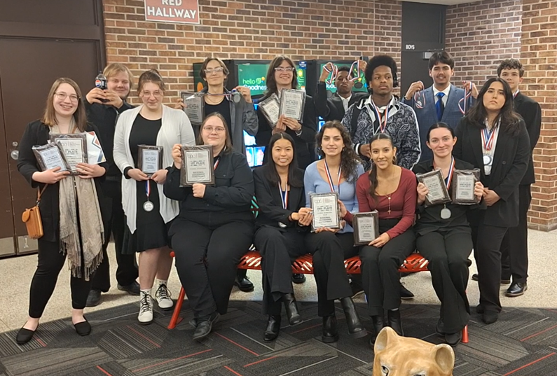 Group of students holding awards, celebrating together after an event.