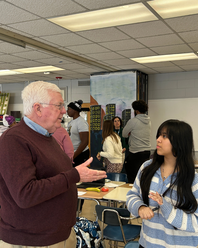 Student speaks with volunteer at WISE event