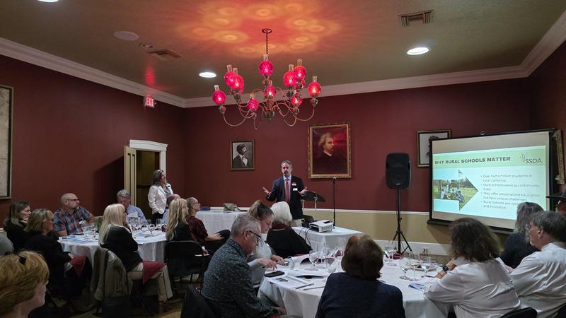 man speaking to group of adults