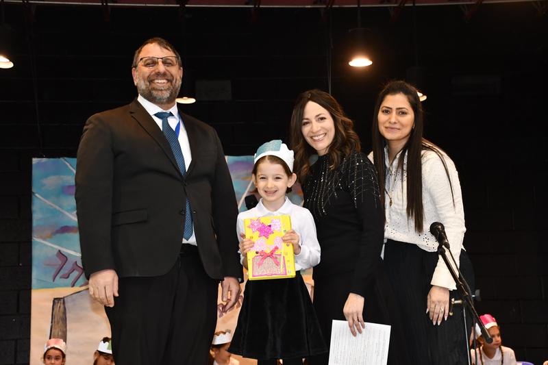A first grader receives her siddur