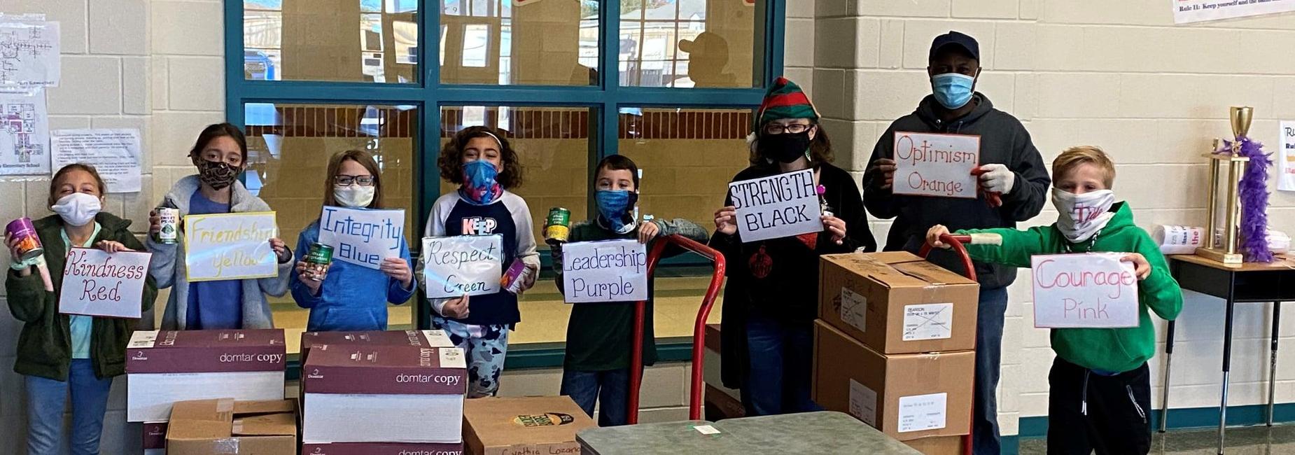 6 students & 2 instructors pose with boxed of donated food items