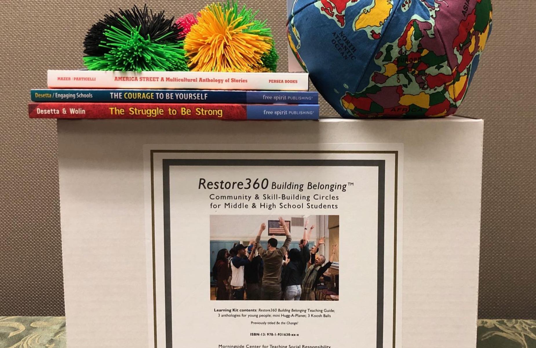 Resource box for community building with books and a globe.