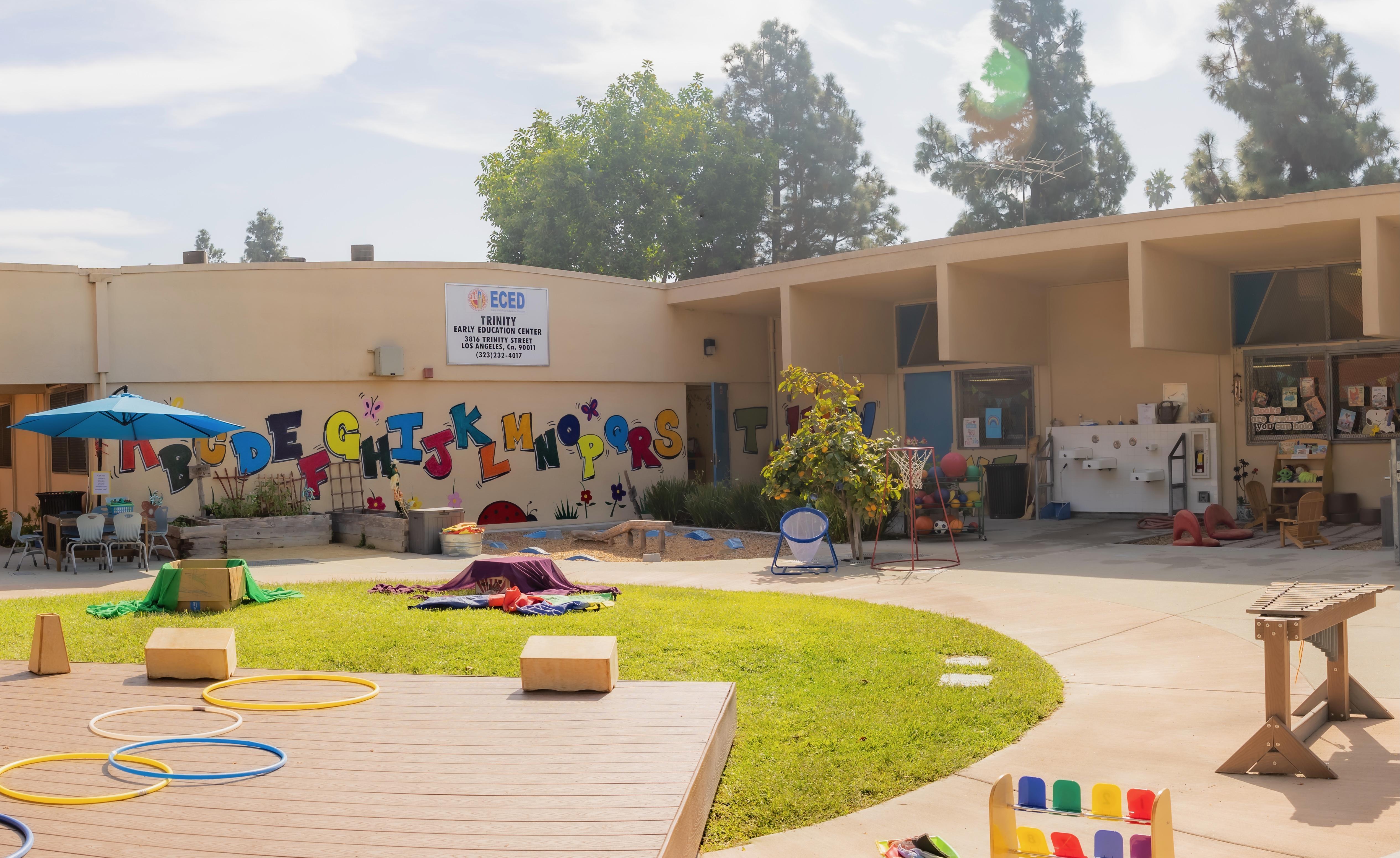 Mural on side of school building and courtyard filled with recess activities
