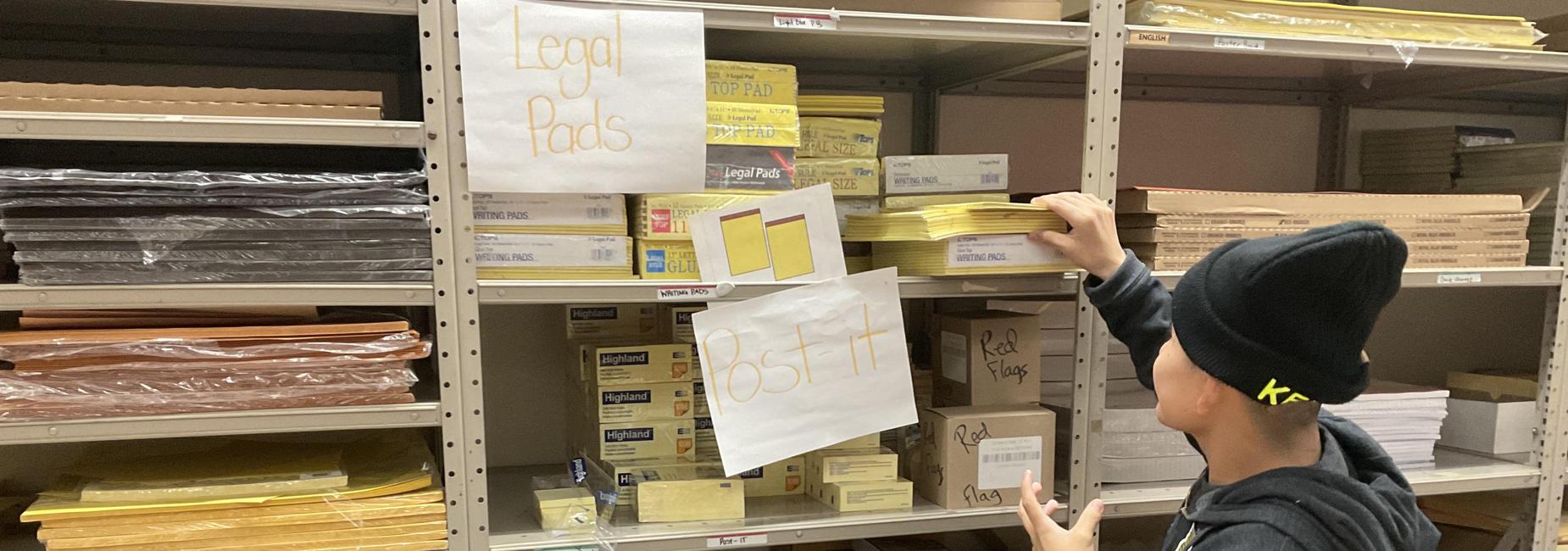 Student grabbing office materials for staff member's request